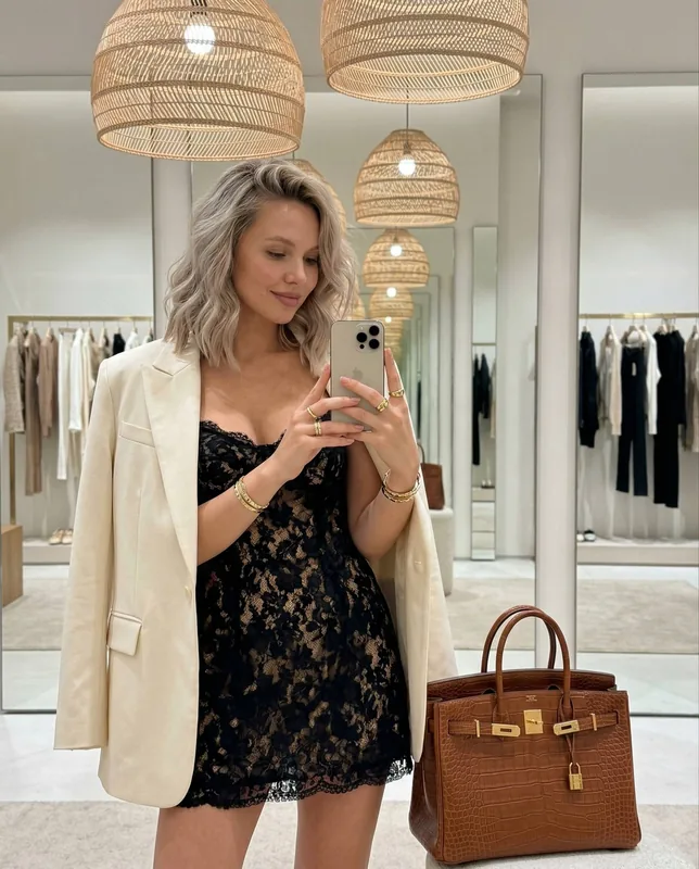 luxurious cozy mirror selfie, preserve face and likeness, subtle forward pose, head slightly down, side glance, long wav
